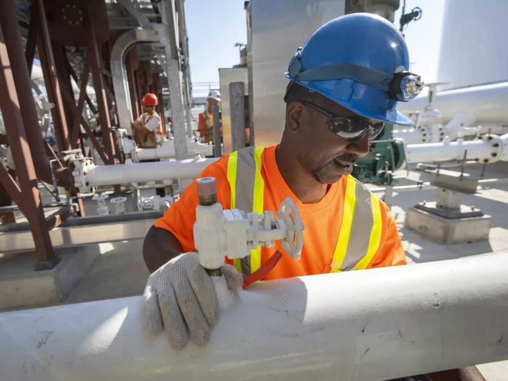 A man working on a construction site in a orange uniform